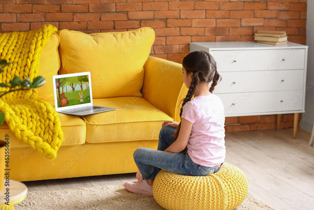 Cute girl watching cartoons at home