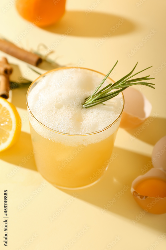 Glass of tasty whiskey sour cocktail on color background