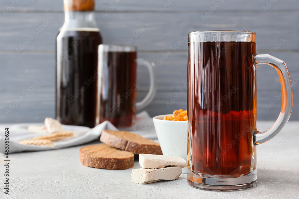 Mug of fresh kvass on wooden background