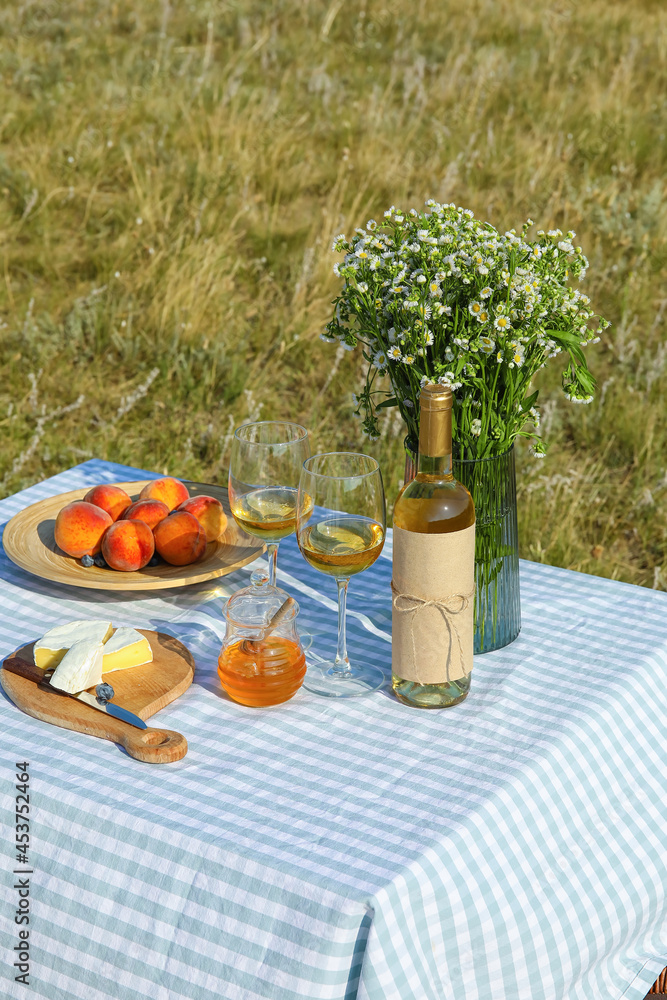 Tasty food and drink for romantic picnic on table outdoors