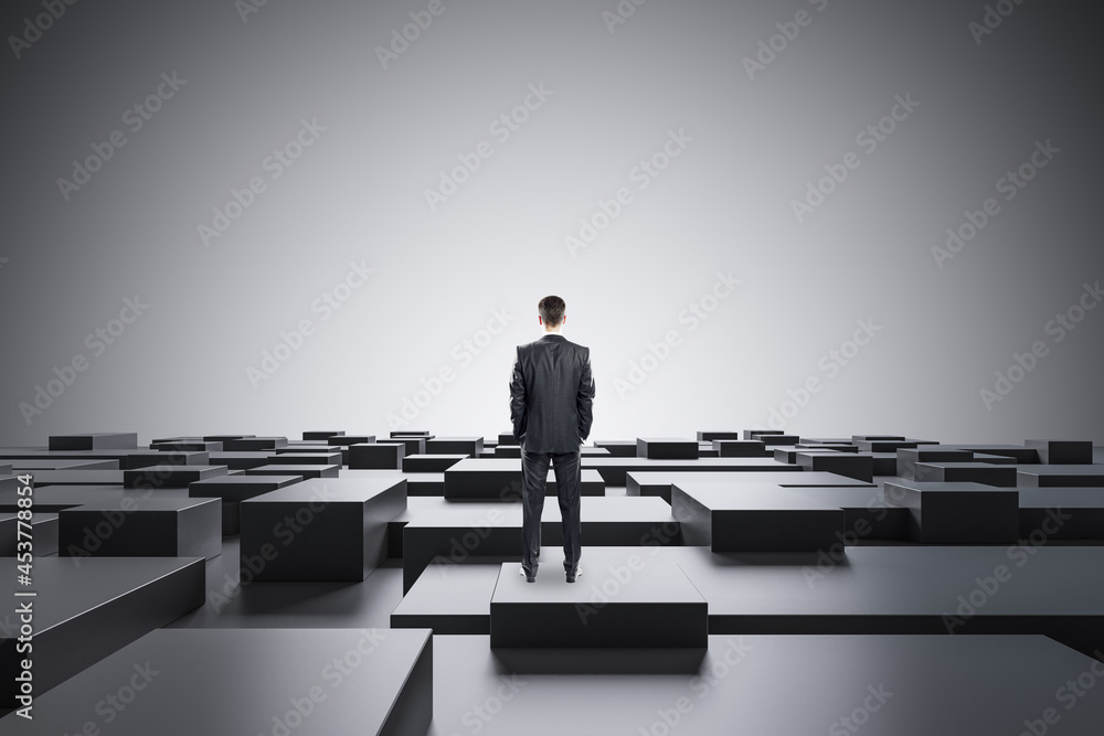 Businessman standing on abstract gray geometric maze background with mock up place. CEO and future c