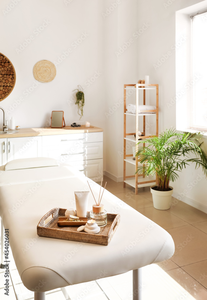 Tray with beautiful spa composition on couch in salon