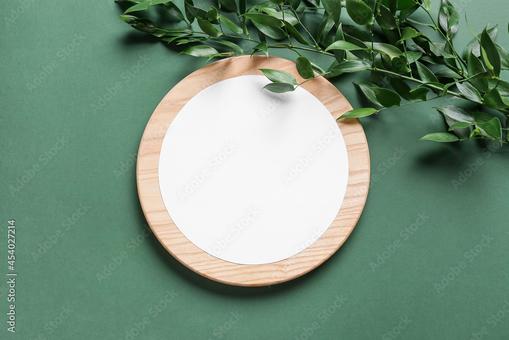 Composition with blank card, wooden board and plant branch on color background