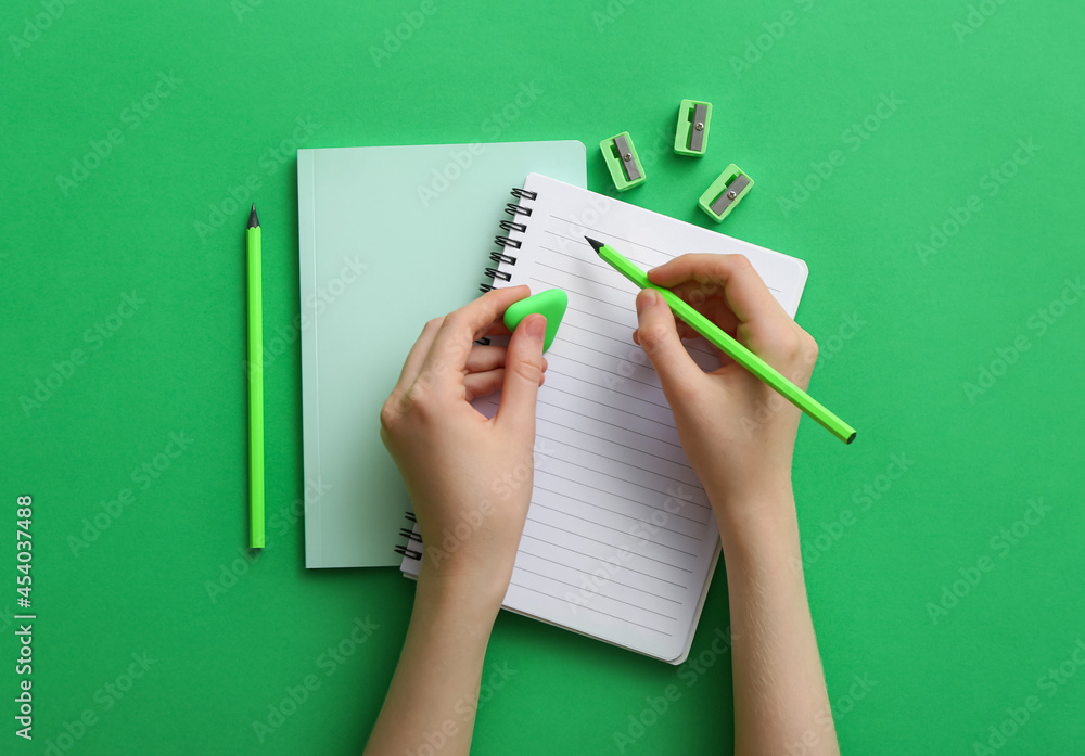 Woman with notebook and stationery on color background