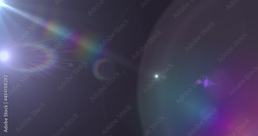 Spot of light and lens flare against black background