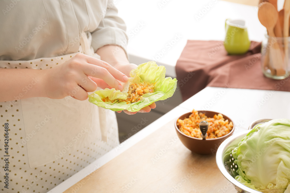 一位女士在厨房的桌子上准备美味的卷心菜馅卷，特写镜头