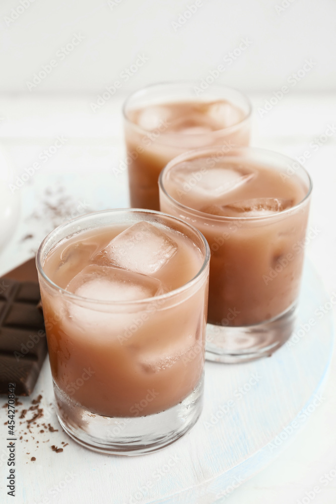 Glasses of tasty chocolate milk on light background, closeup