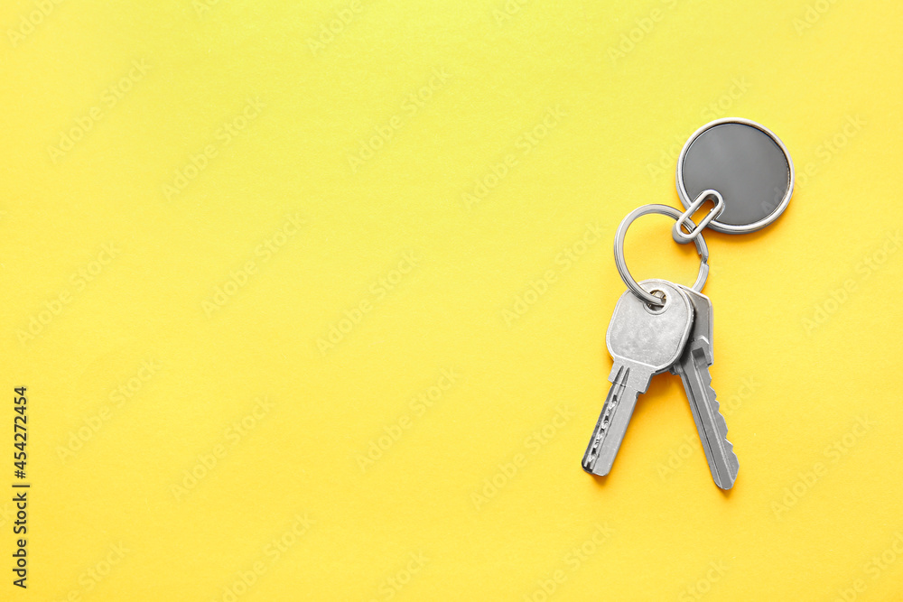 Keys with stylish keychain on color background