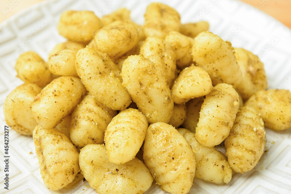 Plate with tasty pesto gnocchi on table, closeup