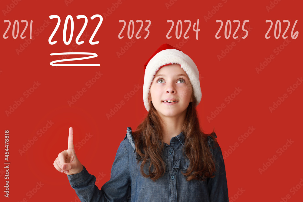 戴着圣诞老人帽子的可爱小女孩指着2022年的数字和其他红色背景的数字