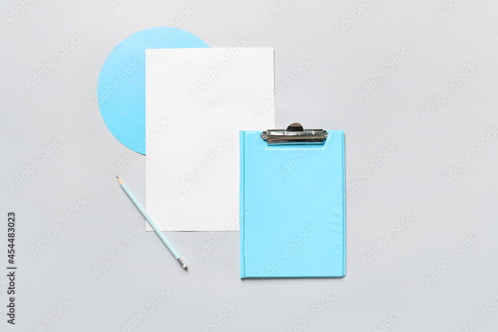 Composition with clipboard, sheet of paper and pencil on grey background