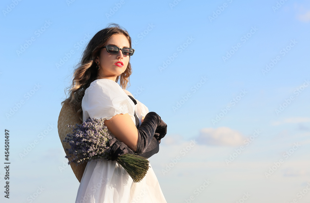 美丽的年轻女子，带着一束薰衣草在户外