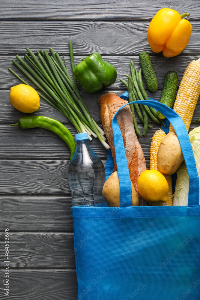 Eco bag with different products on wooden background