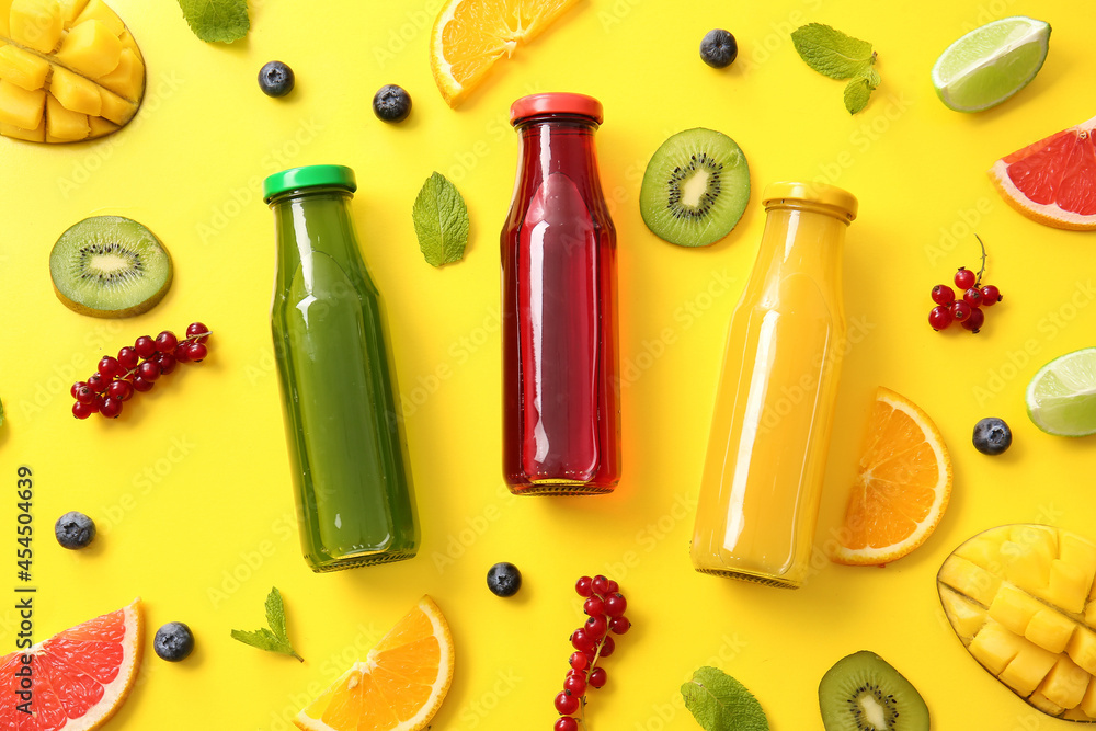 Bottles with healthy juice and fruits on color background