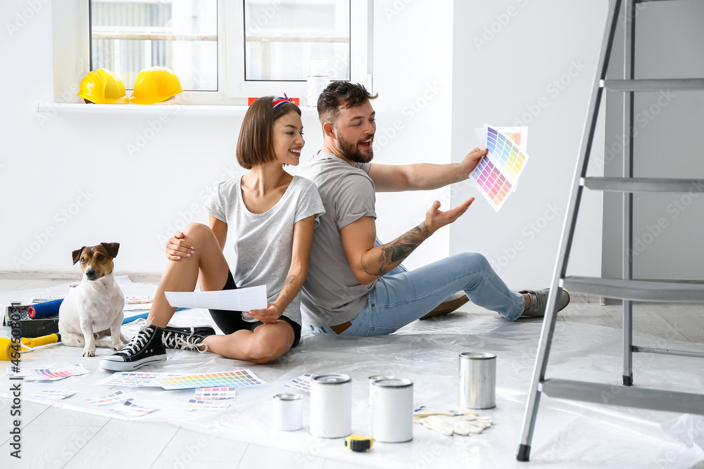 Young couple with cute dog and palette samples planning design of their new house