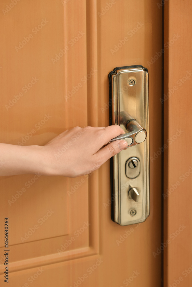 Woman opening door in room, closeup