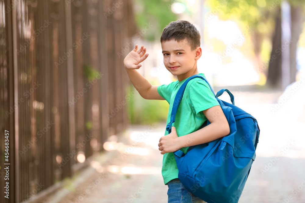 Little schoolboy with backpack outdoors