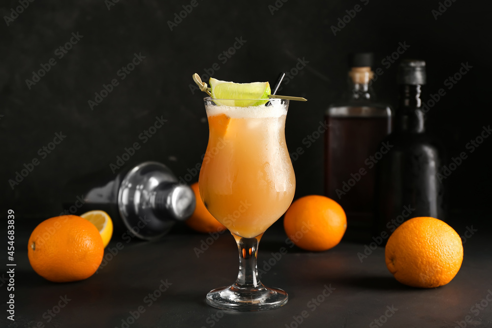 Glass of tasty whiskey sour cocktail on dark background