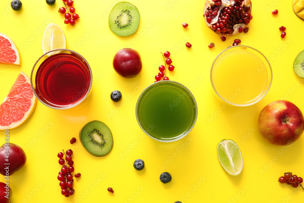 Glasses with healthy juice and fruits on color background