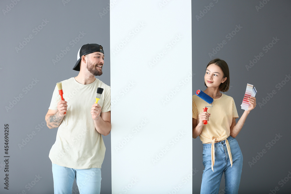 Young couple with painters tools in their new house