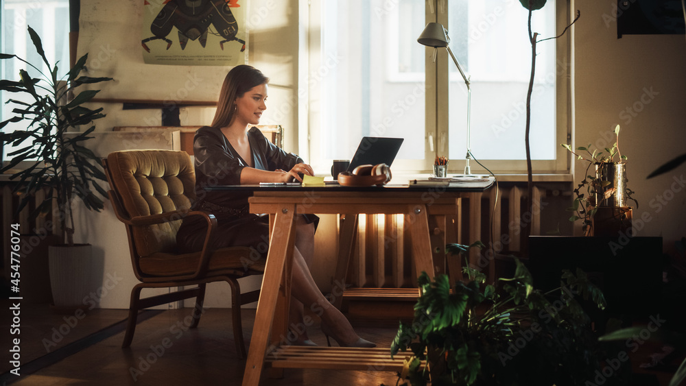 年轻漂亮的女性在Authentic Loft Office.Renov创意机构的笔记本电脑上工作