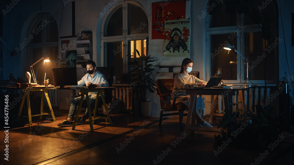 Two Stylish Employees Wearing Protective Face Masks while Working on Computers in Creative Agency in