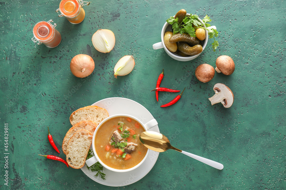 Bowl with tasty beef barley soup on color background