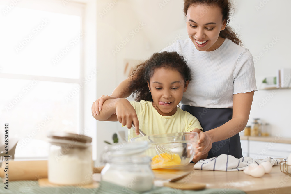 非裔美国小女孩和她的妈妈在厨房做饭