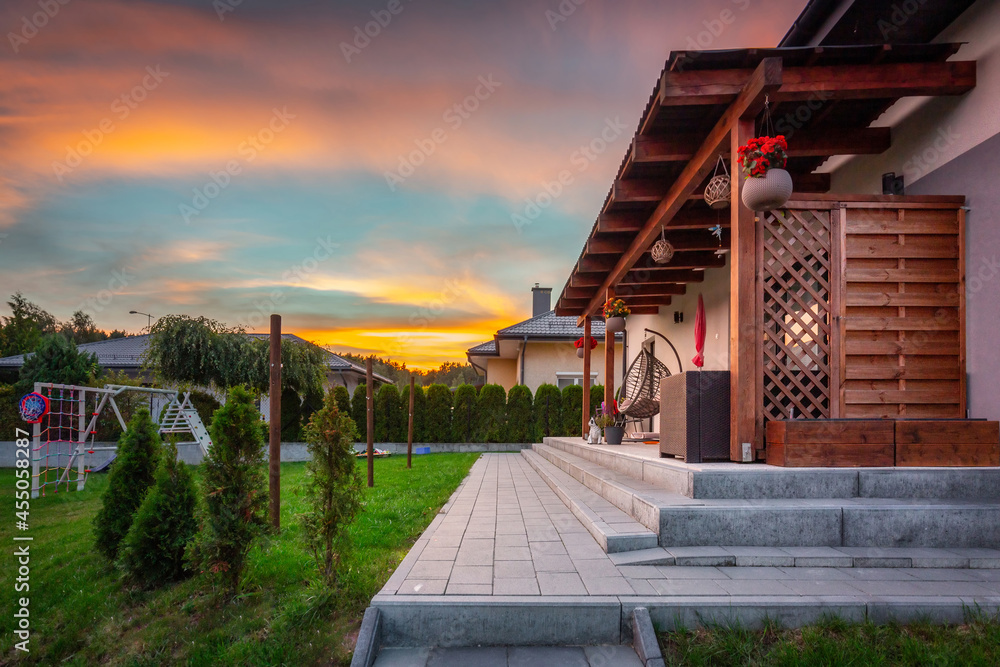 A modern single family house with a garden at sunset