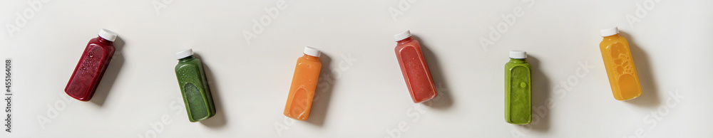 Flat-lay of fresh natural organic juices in bottles, wide composition