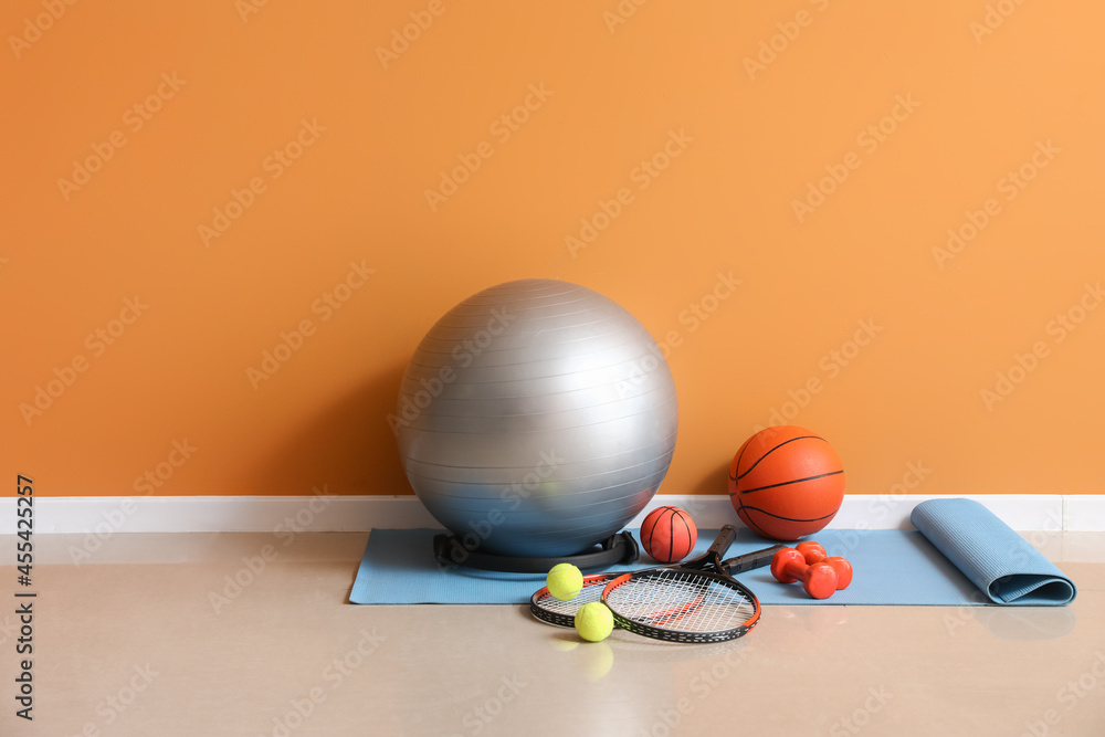 Set of sports equipment on floor near color wall