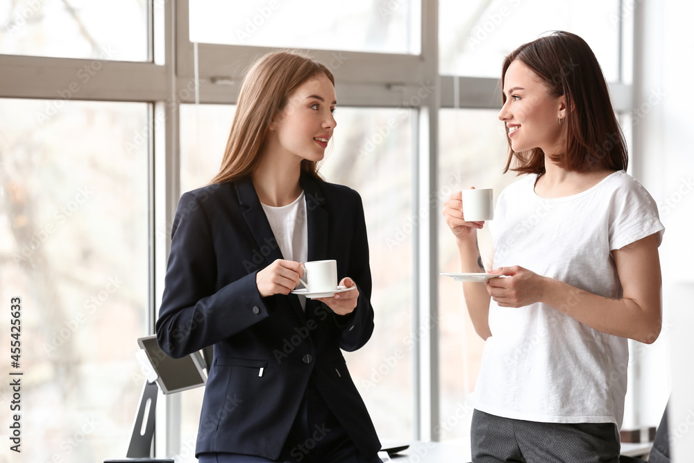 Female colleagues drinking coffee in office