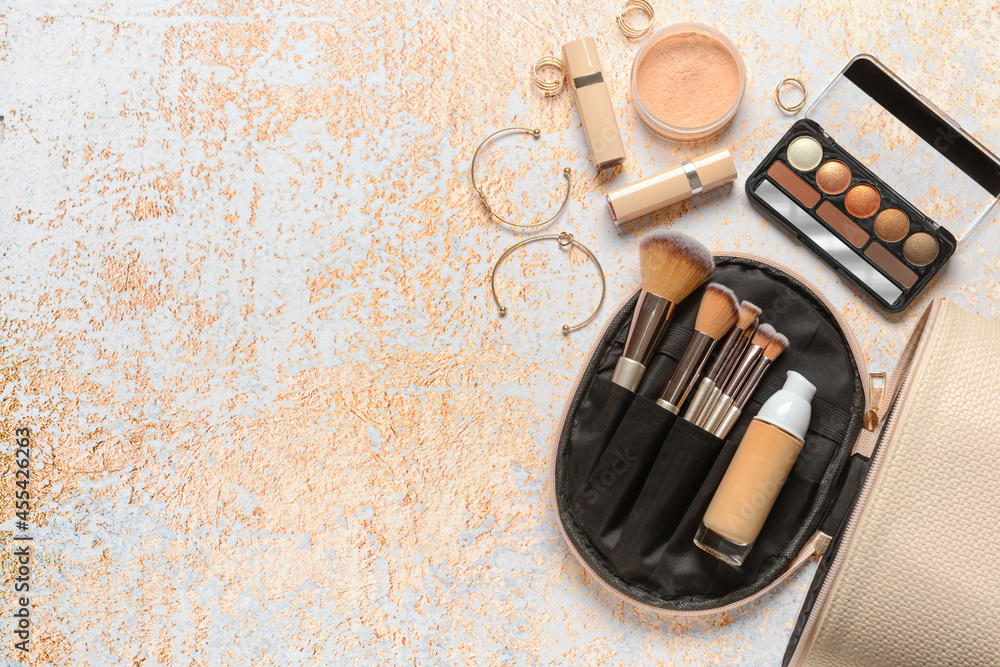 Stylish bag and decorative cosmetics on color background