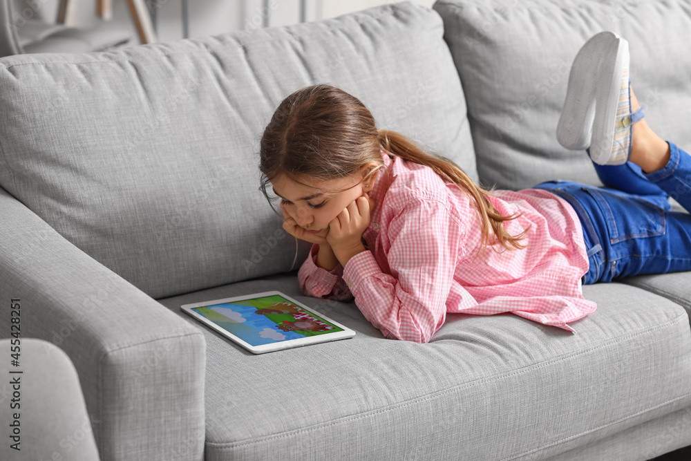 Cute girl watching cartoons at home