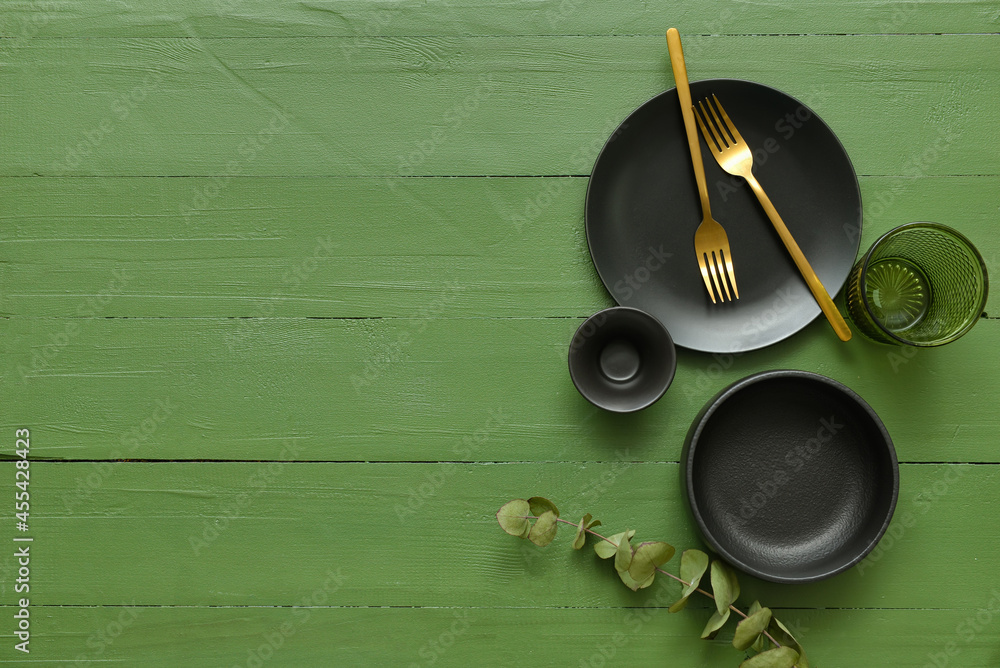 Different tableware on color wooden background