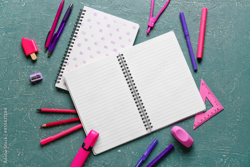 Blank notebook and stationery supplies on color background