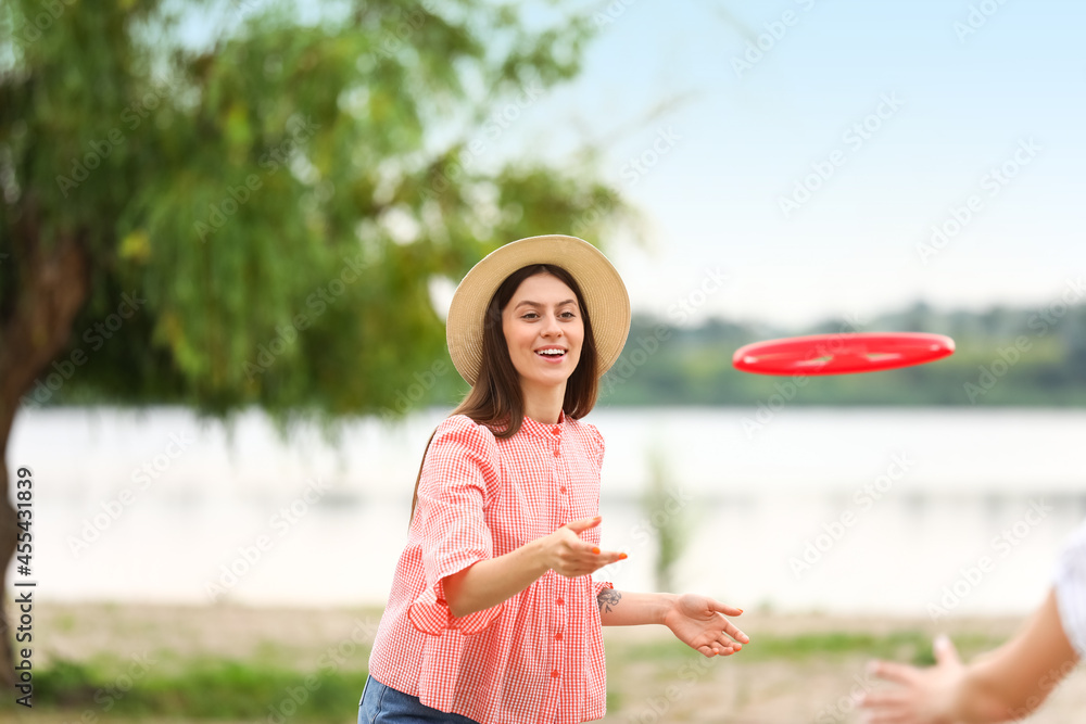 美丽的年轻女子在户外玩飞盘