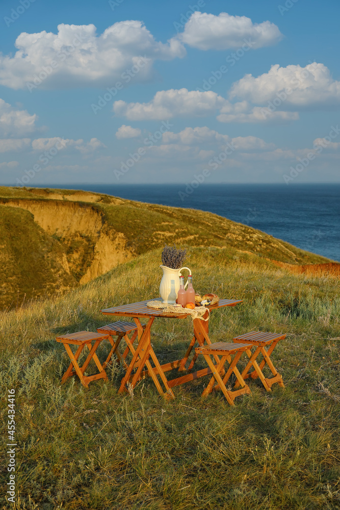 Tasty food and drink for romantic picnic on table outdoors