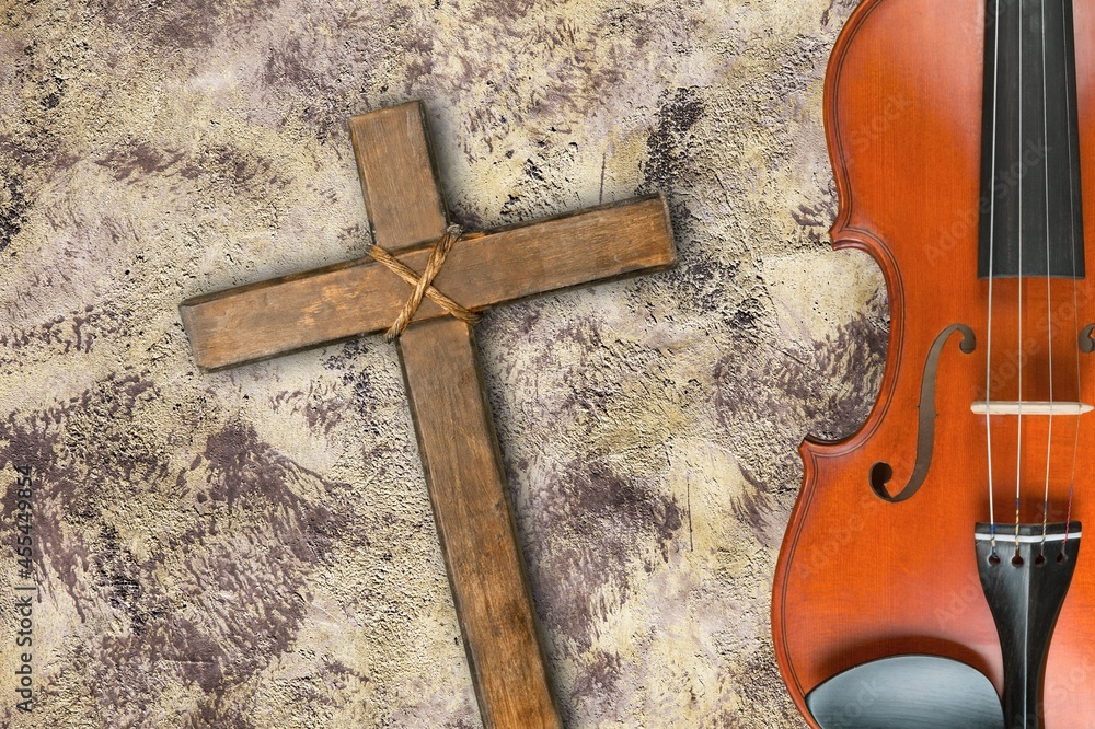 Wooden cross over classic violin on a desk