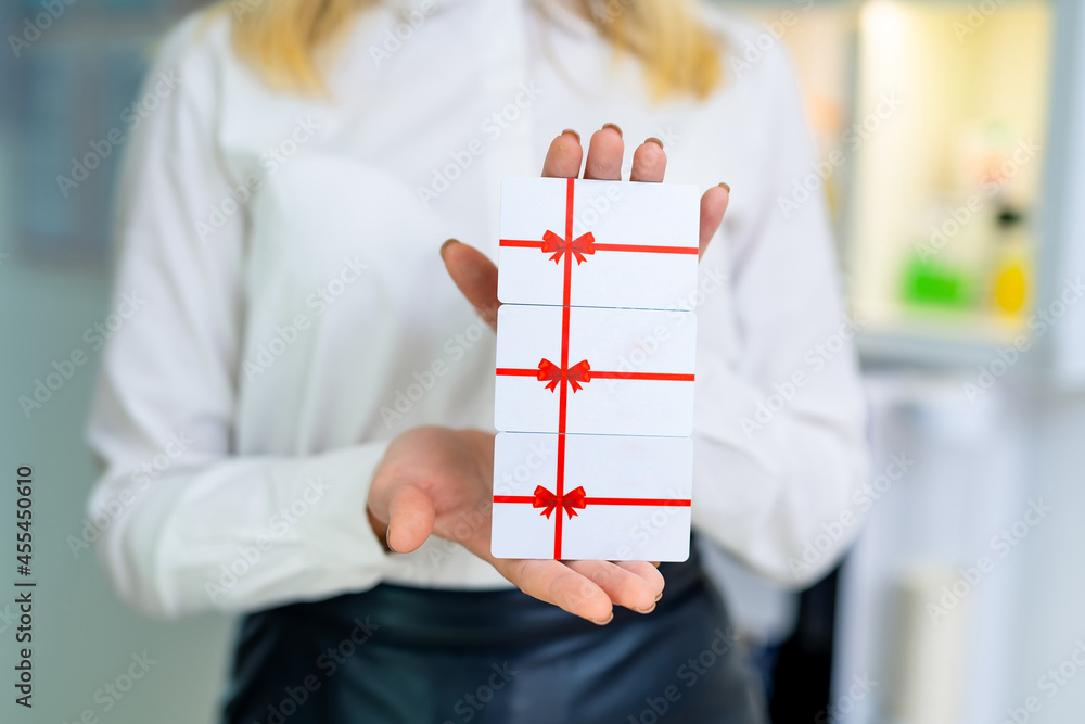 Gift cards in woman`s hands. Close up of woman`s hands with cards.