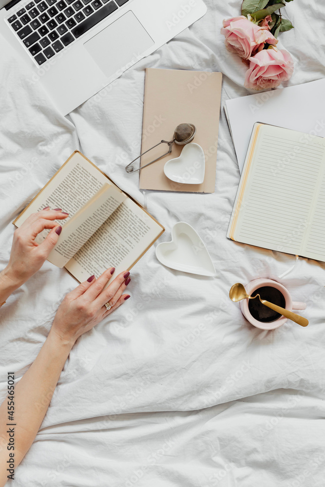 Woman reading a novel on her bed on a Sunday afternoon