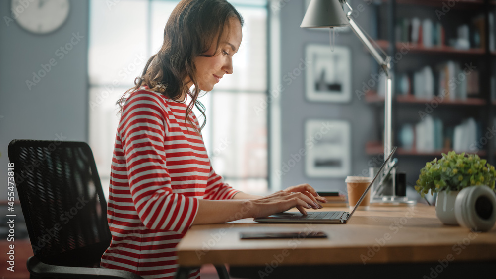 Young Woman Using Laptop at Home for Remote Work. Beautiful Young Brunette Girl Sitting at Her Desk 