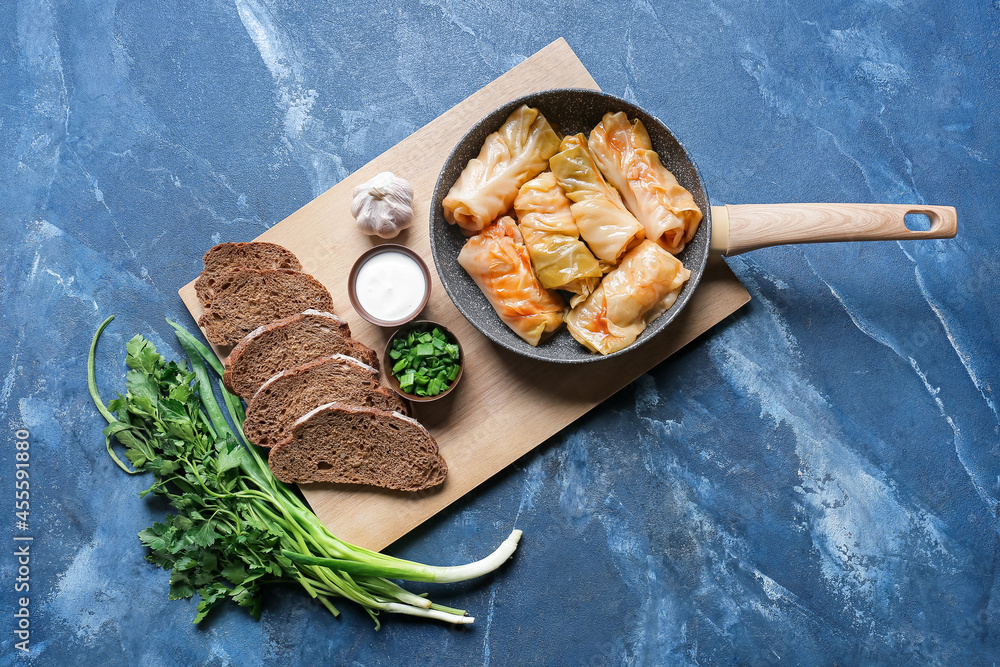 Composition with tasty stuffed cabbage rolls on color background