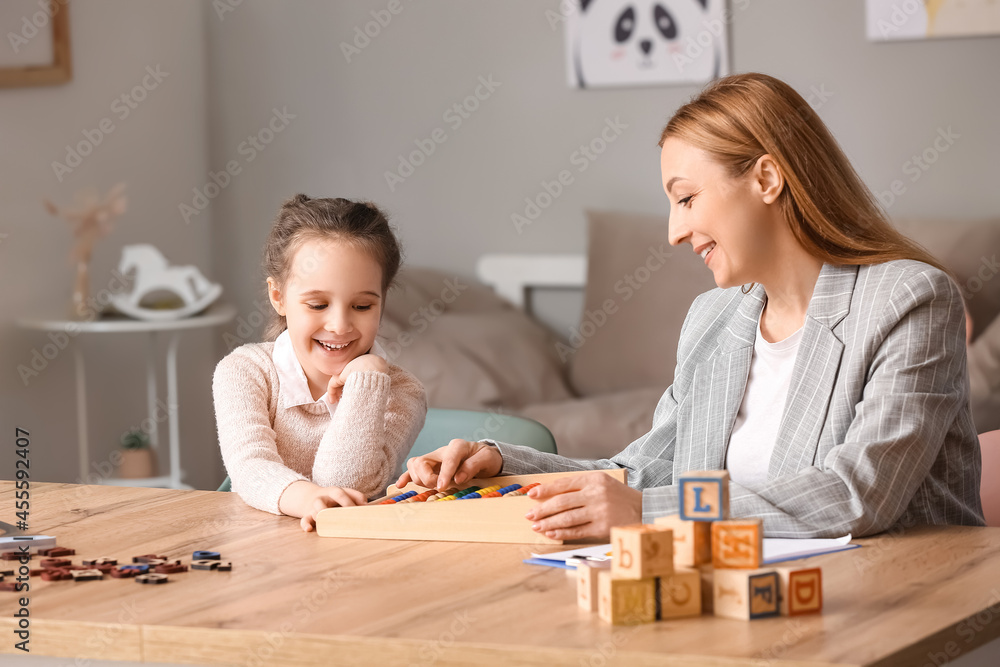 Female psychologist working with girl suffering from autistic disorder in office