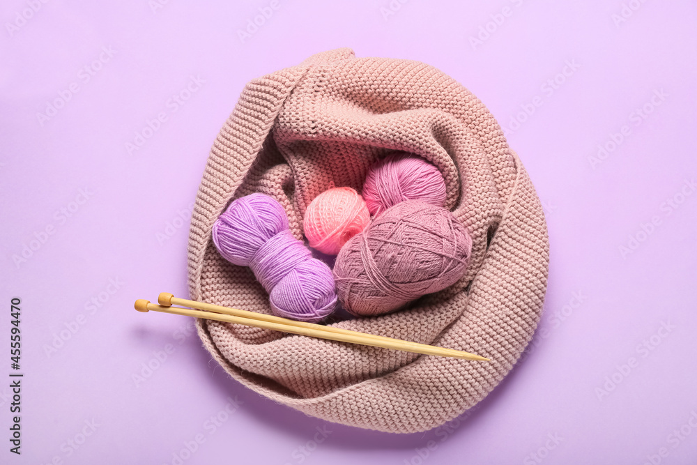 Knitting yarn and needles on color background