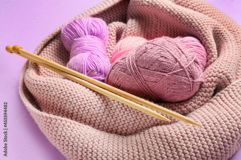 Yarn and knitting needles on color background, closeup