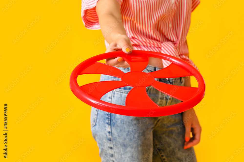 Beautiful young woman with frisbee disk on color background, closeup