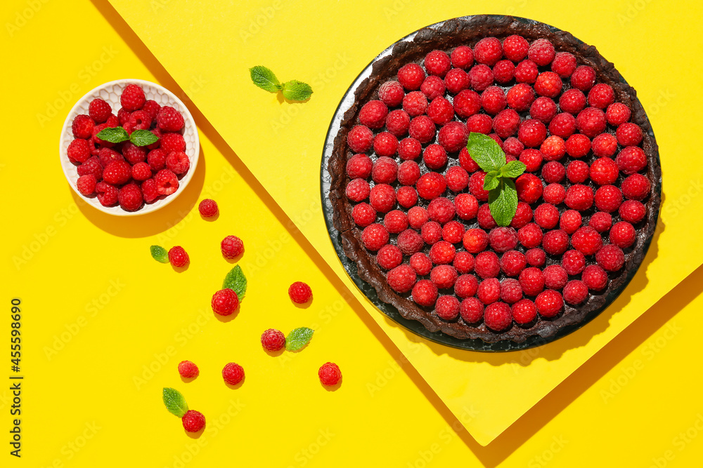 Board with tasty raspberry pie and mint on color background