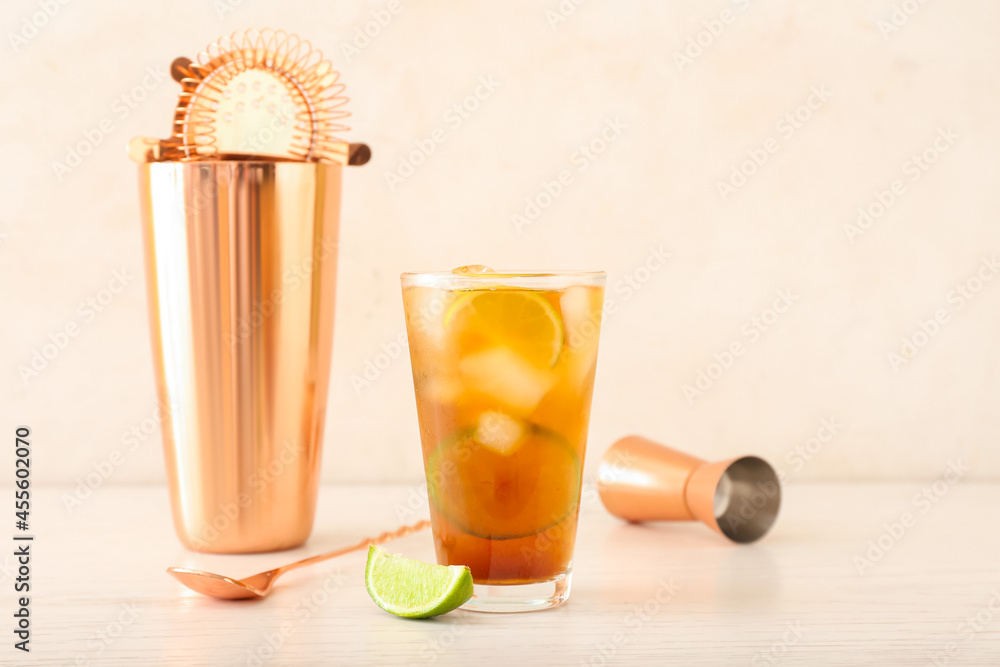 Glass of tasty Long Island iced tea on light background