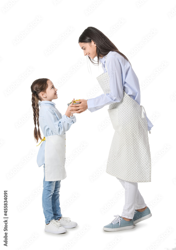 Young mother and daughter with tasty dish in saucepot on white background